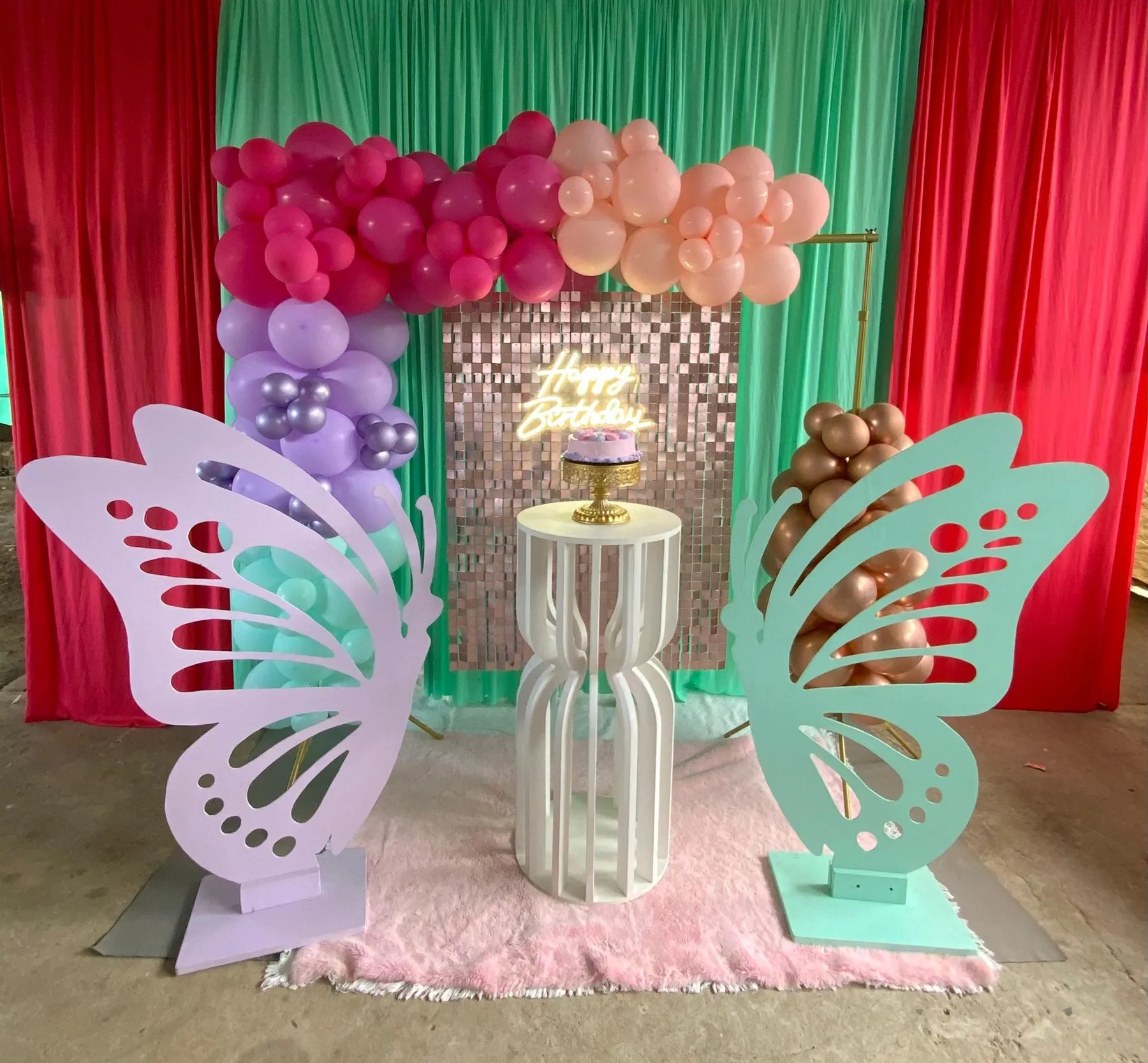 Cumpleaños con mariposas gigantes, globos y cortinas de colores