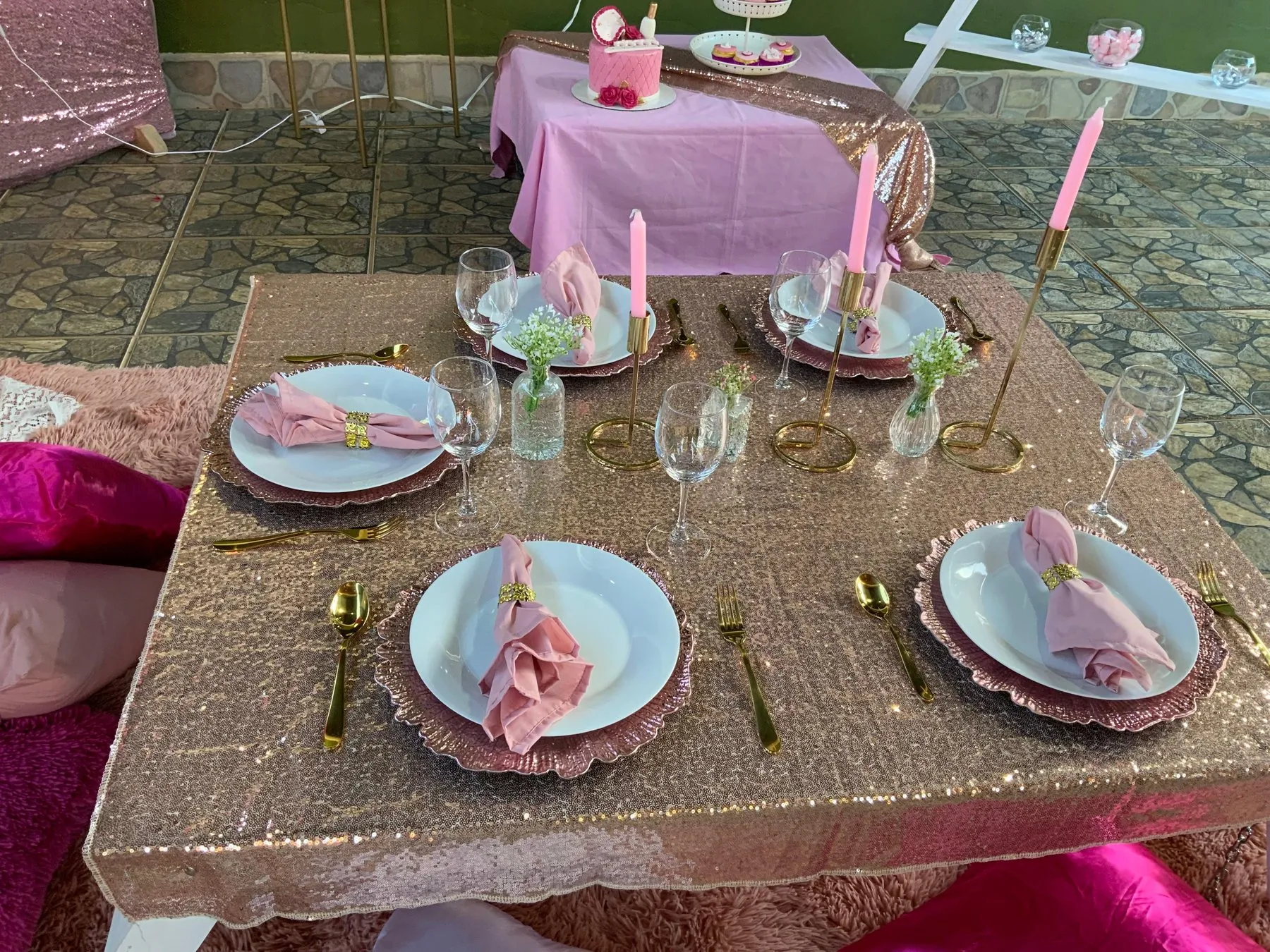 Mesa baja de fiesta infantil con platos, servilletas rosadas y queque de cumpleaños