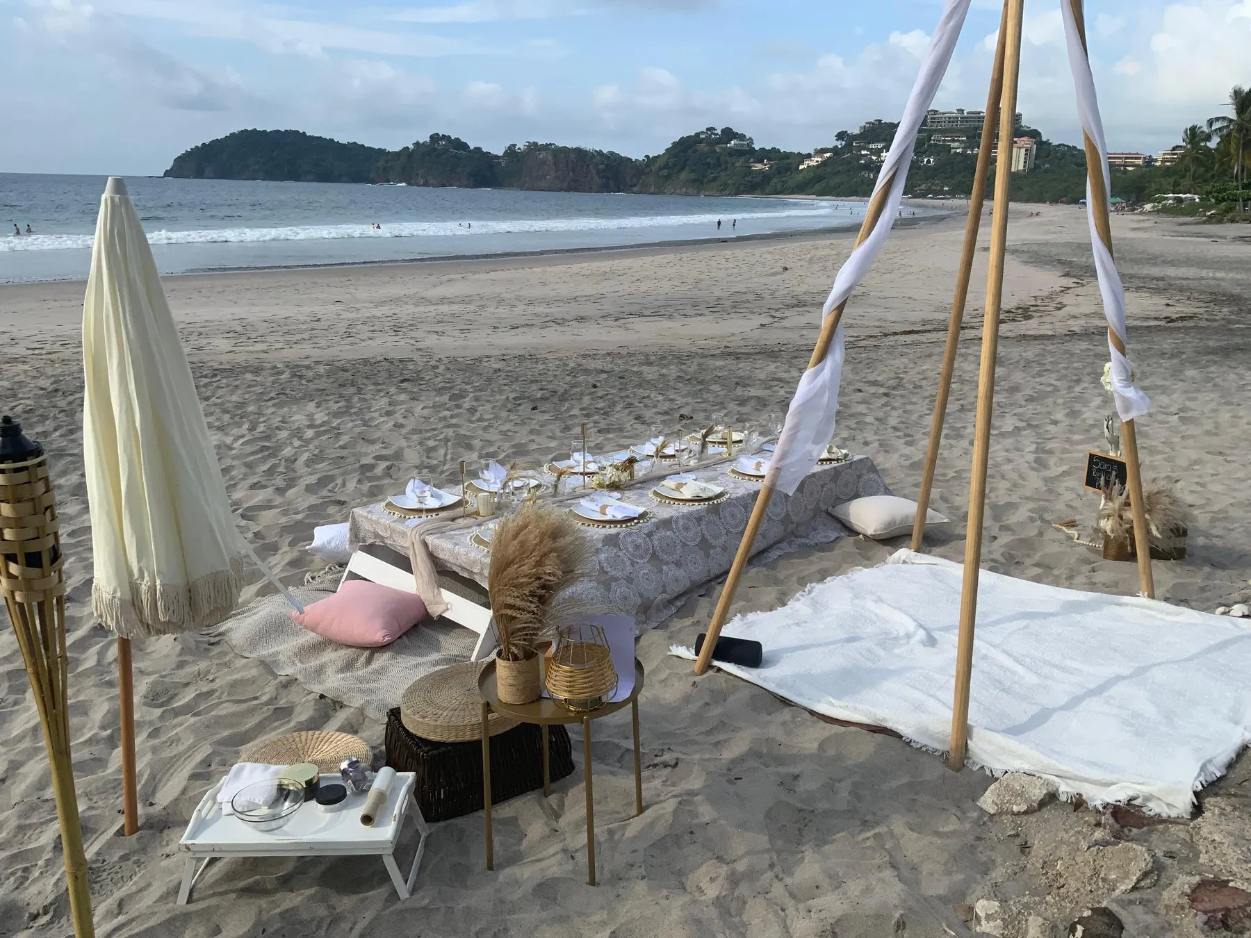 Picnic en la playa con sombrilla, tipi y mesa baja
